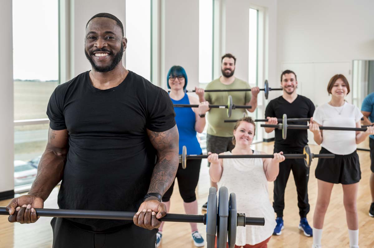a group of people smiling for a photo and lifting weights