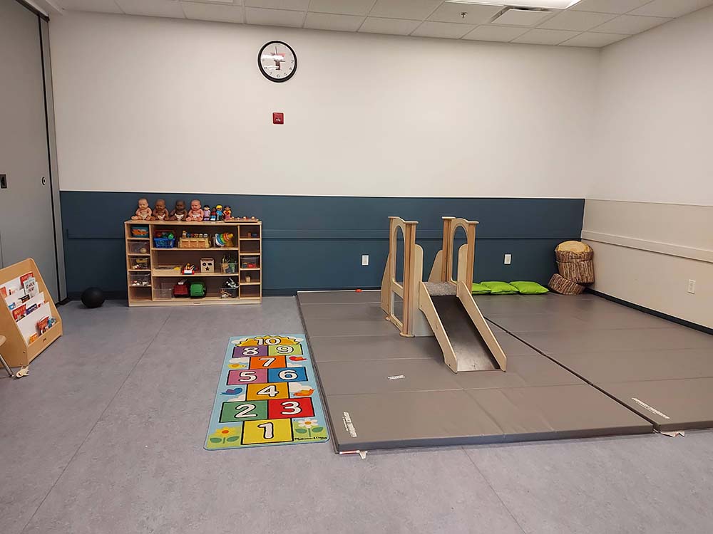 A rental room showcasing play mats and shelves with toys