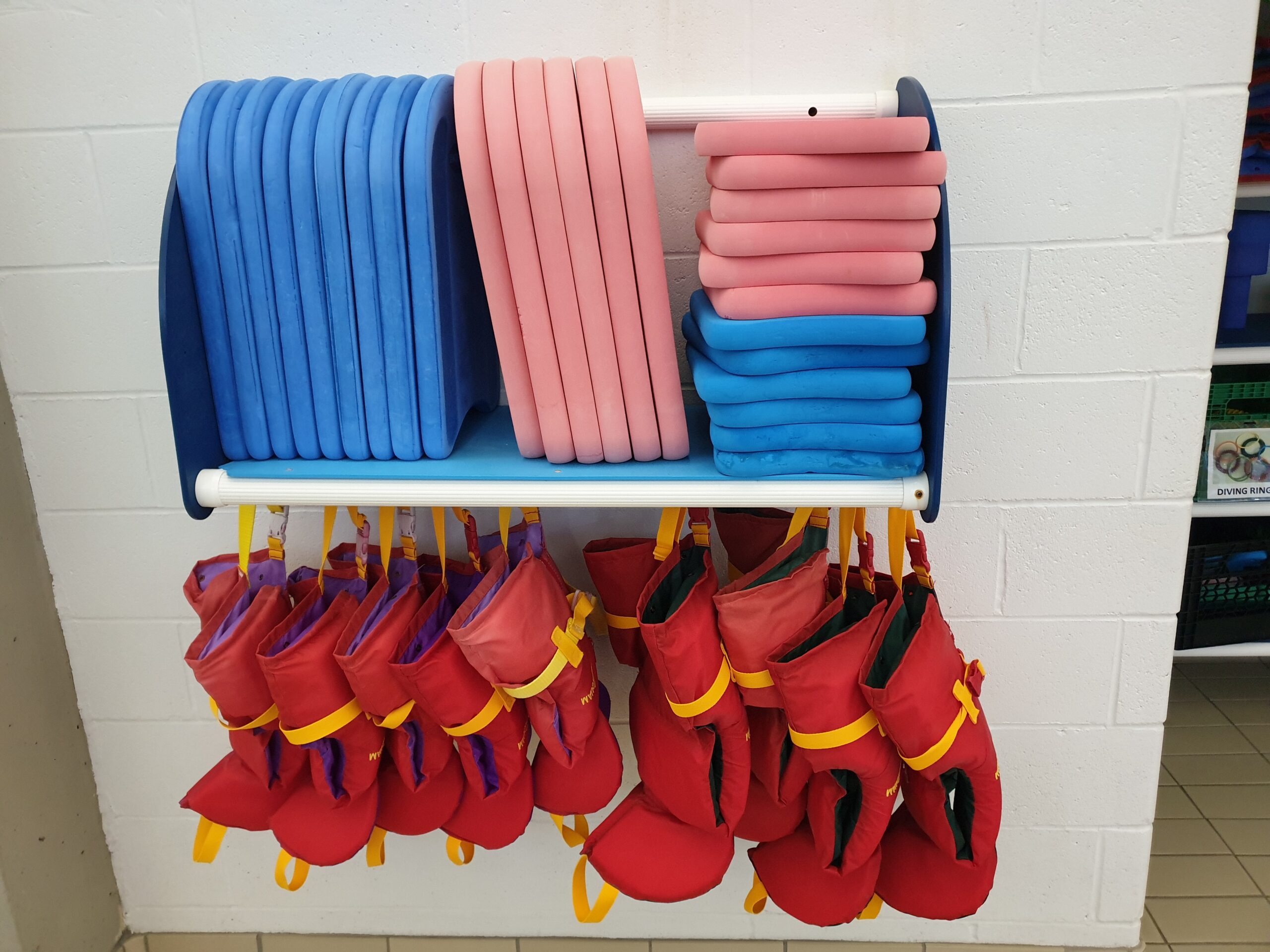 a shelf of life jackets and kickboards for children