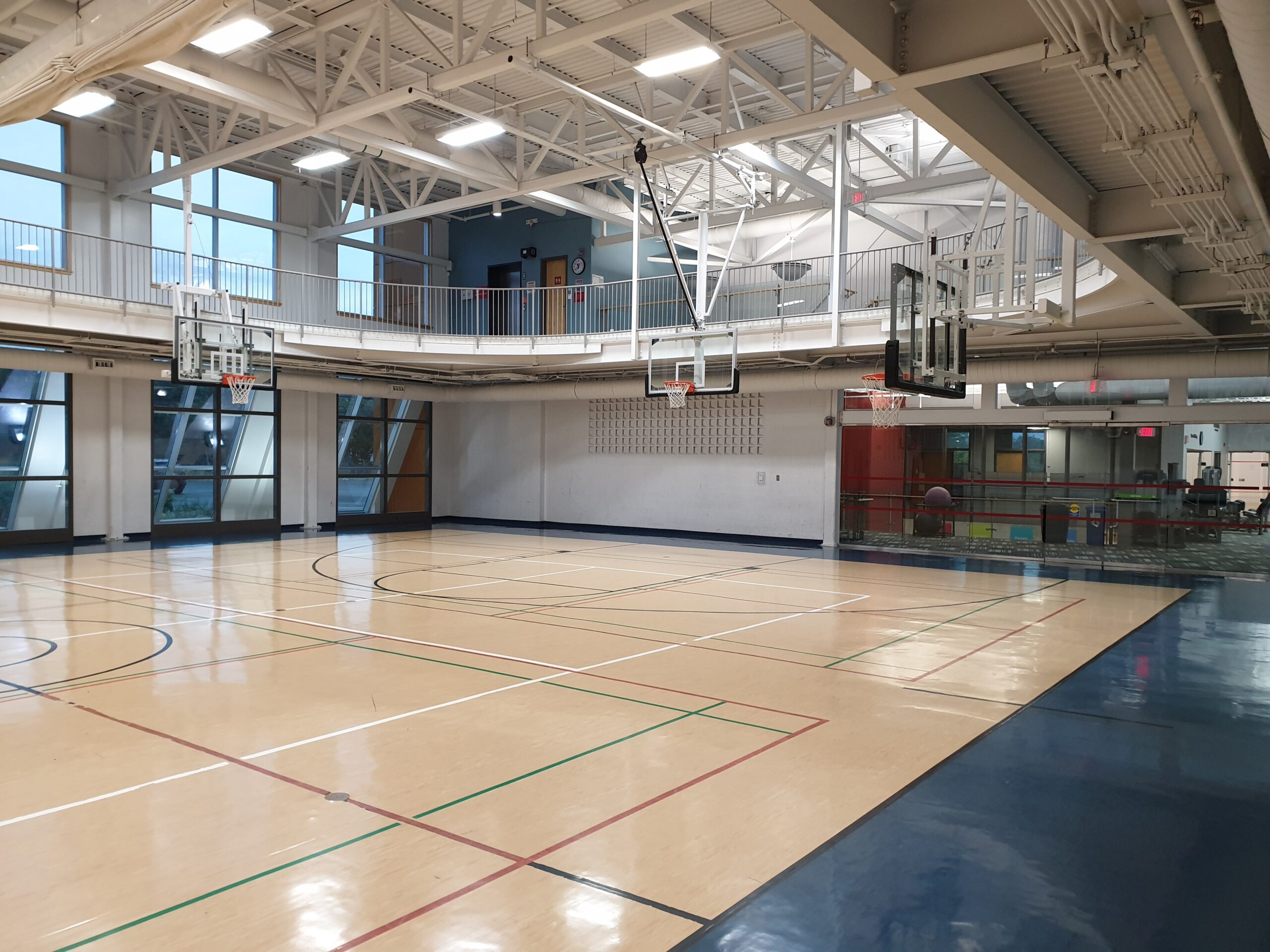 A gymnasium with basketball nets below the walking track