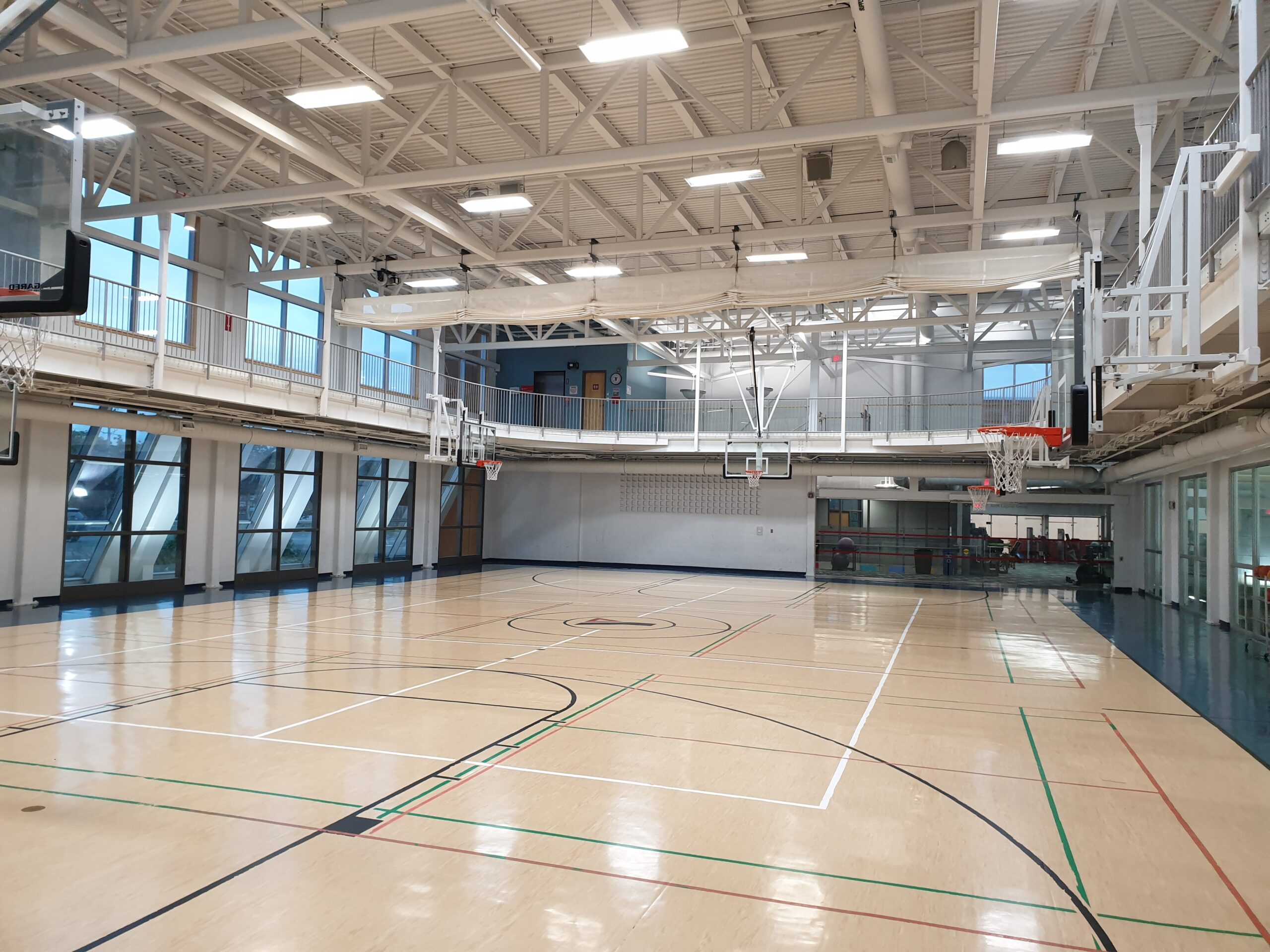 A gymnasium with basketball nets below the walking track
