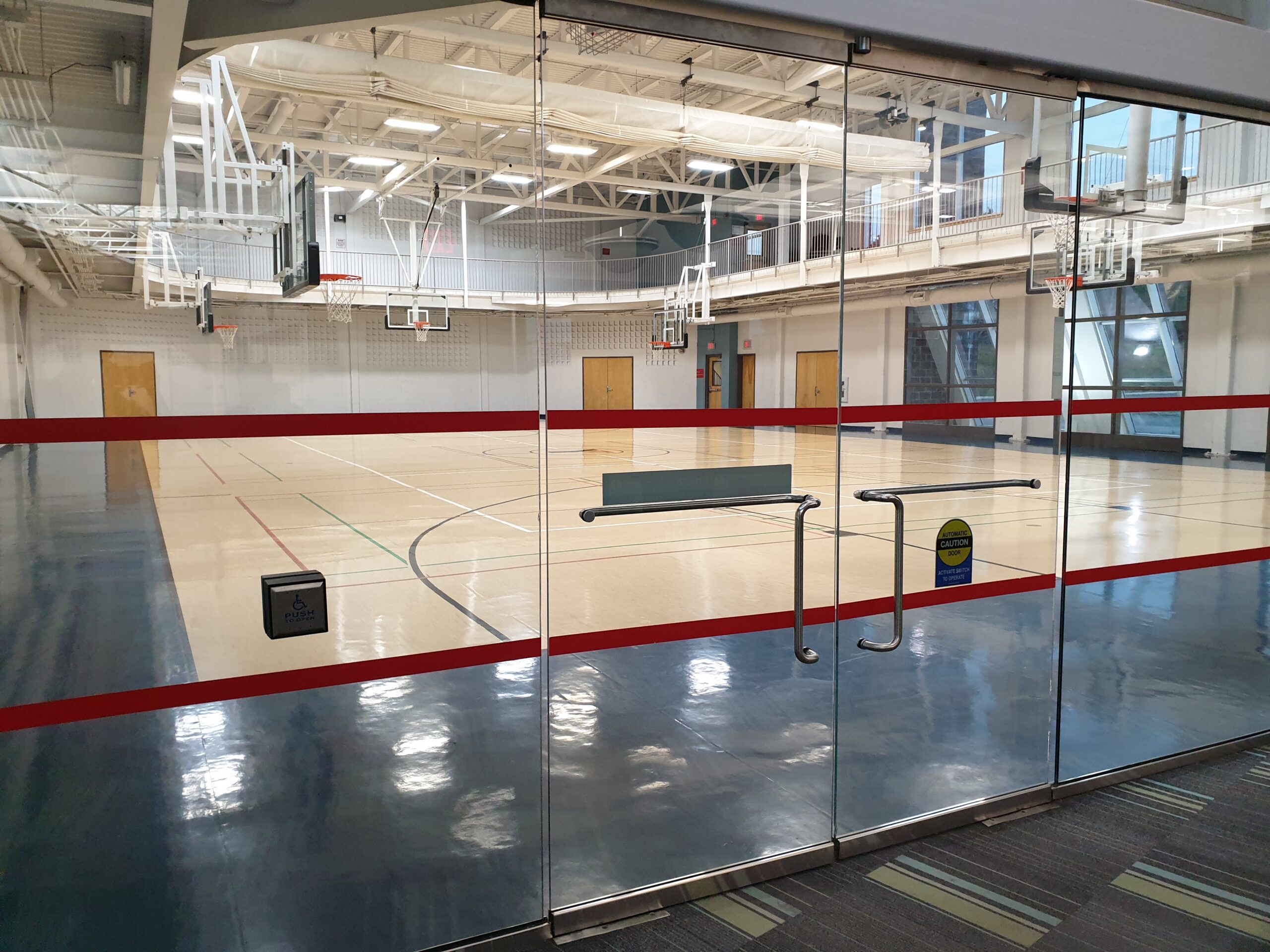 The exterior of a gymnasium with basketball nets below the walking track