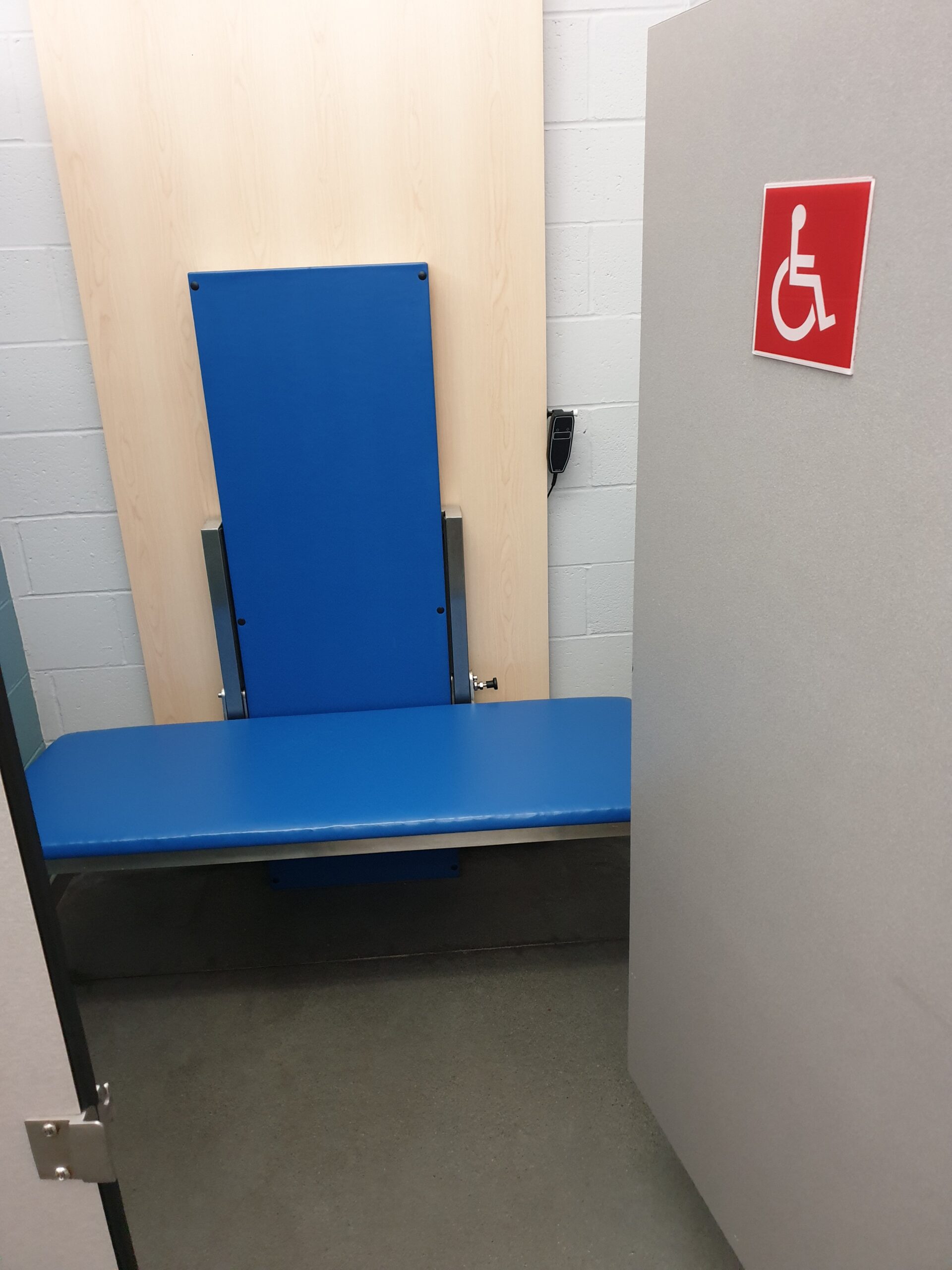 a wheelchair accessible changing room with a bench