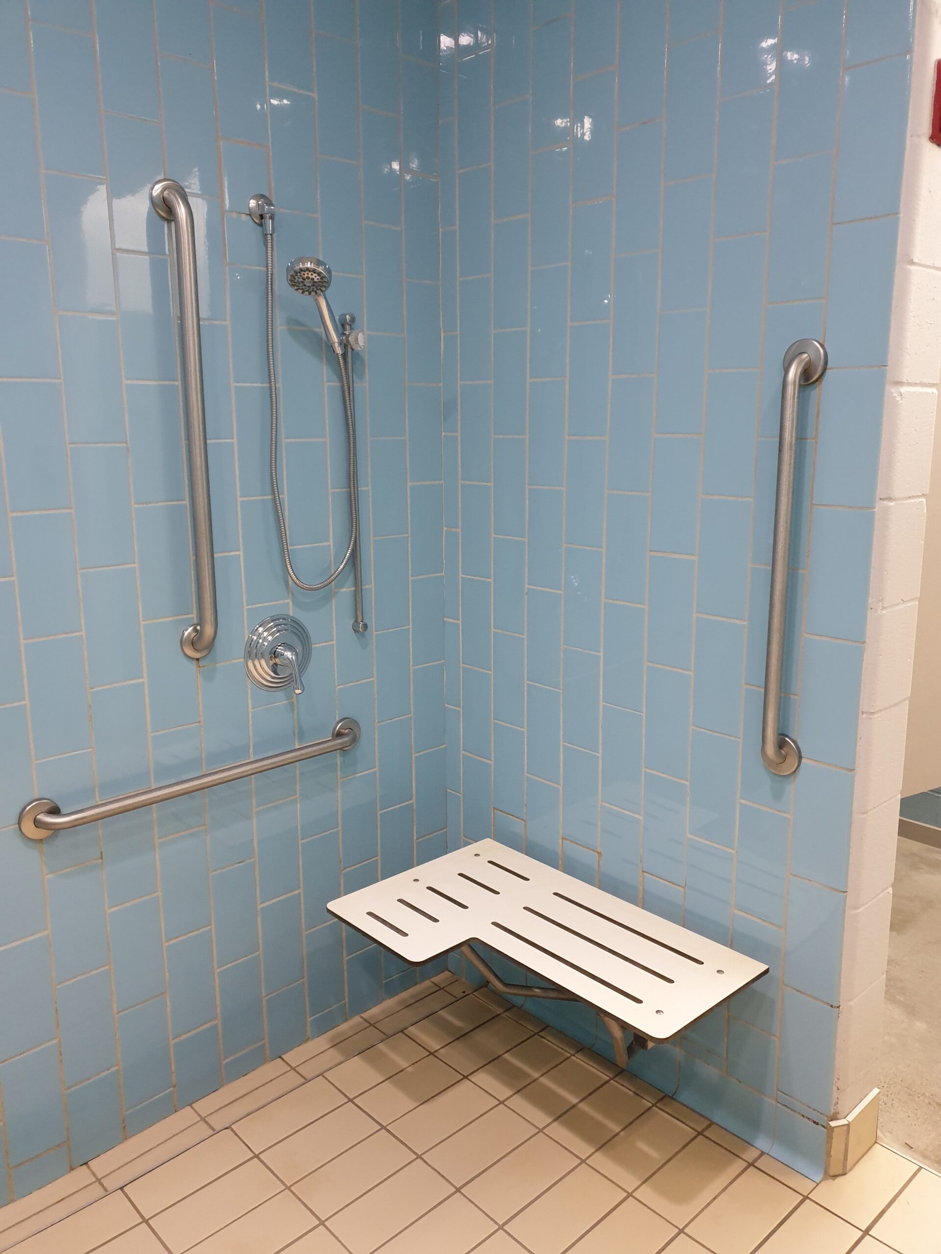 a shower in a YMCA changing room with accessibility equipment