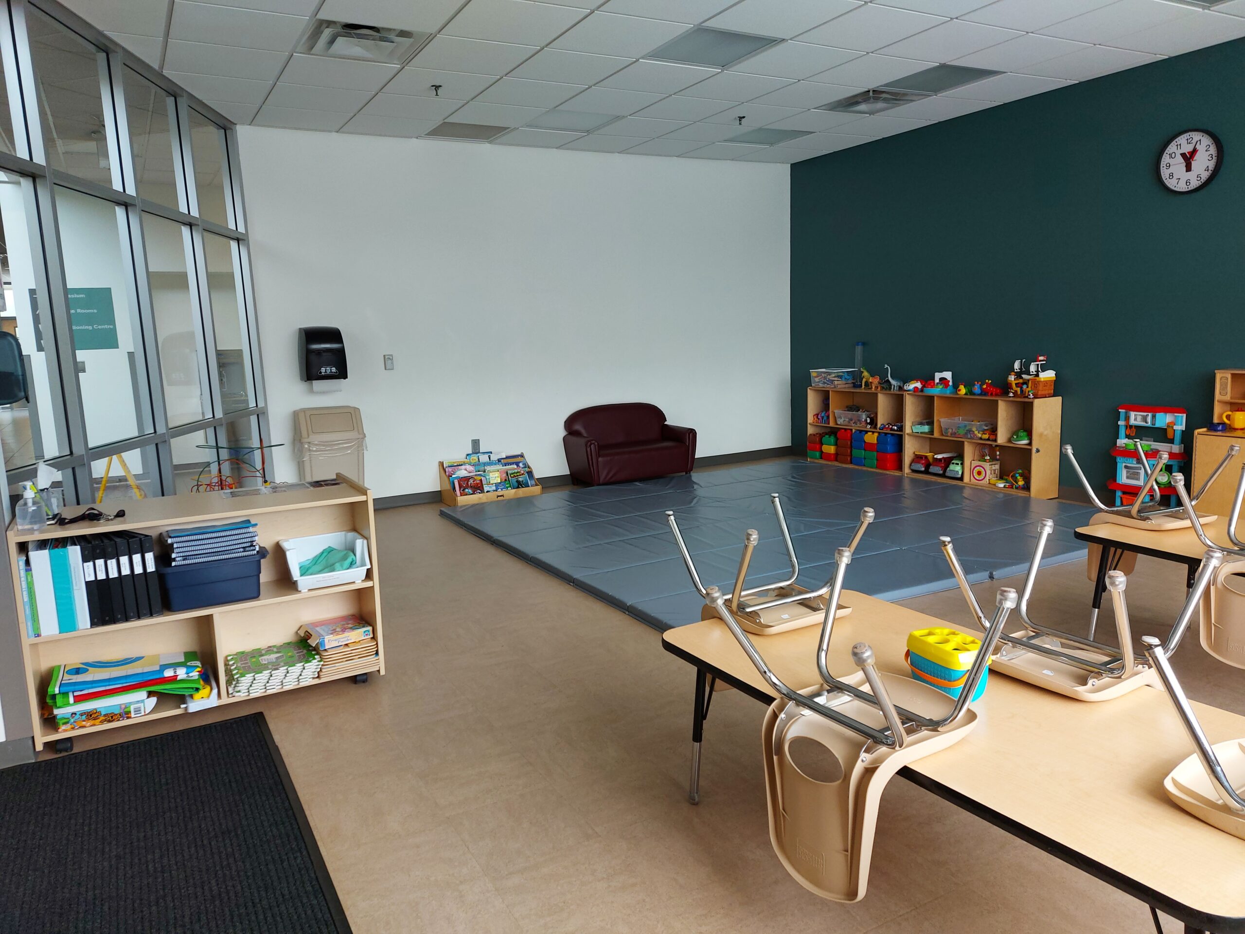 a wide angle view of a rental room at the YMCA with children's tables and toys