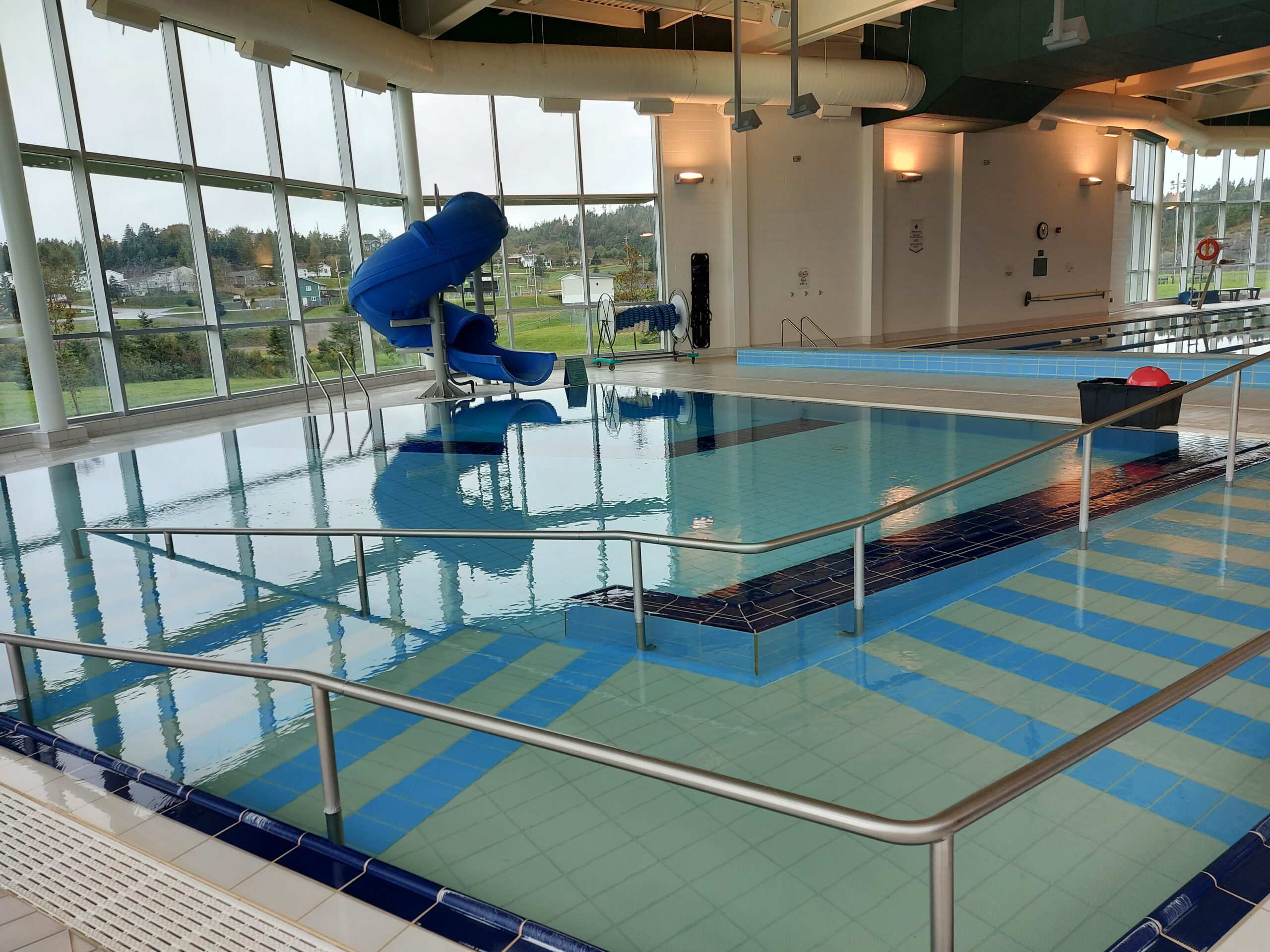a wide view of a smaller indoor swimming pool with a slide