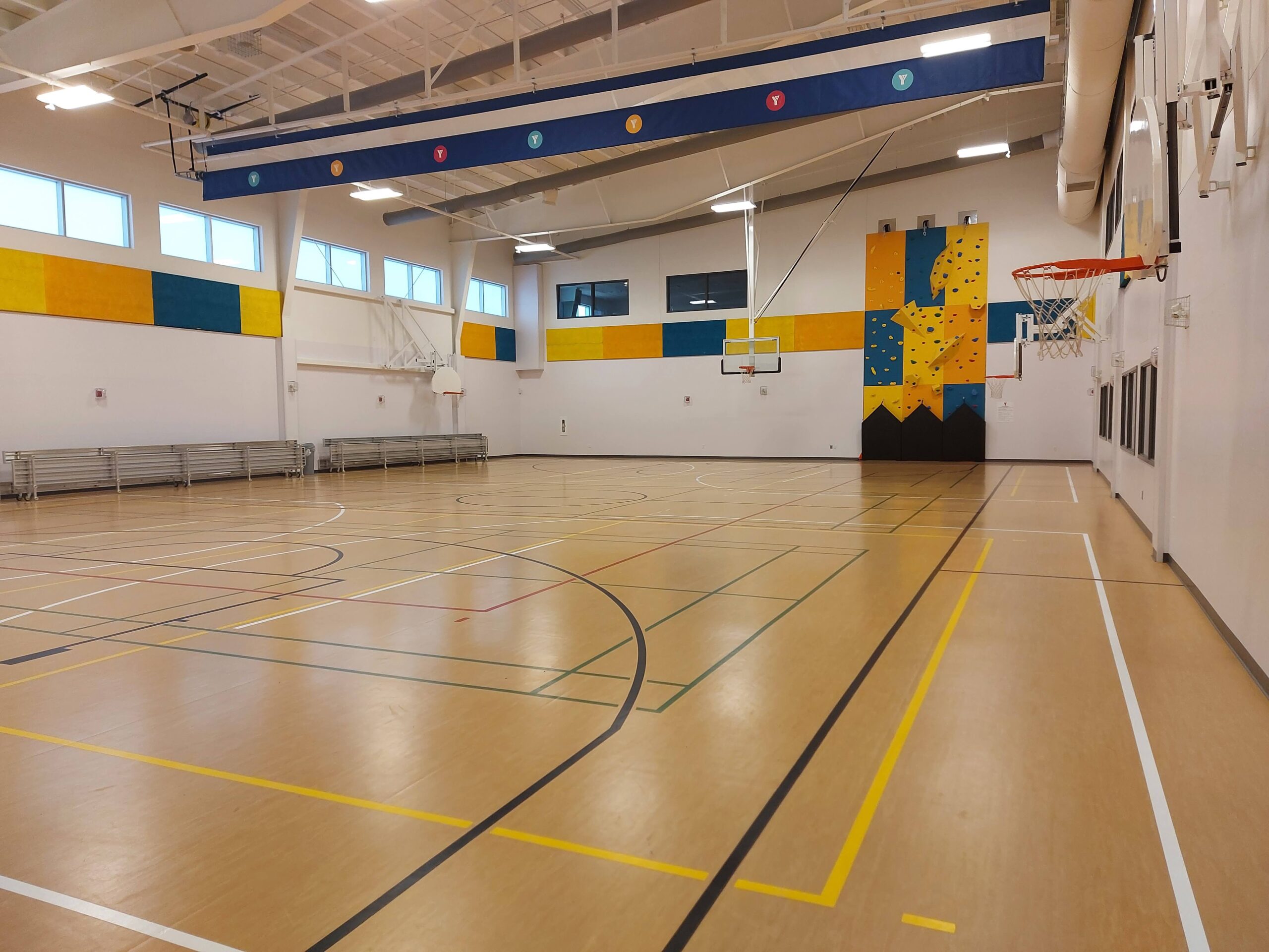 wide view of a gymnasium with a rock climbing wall